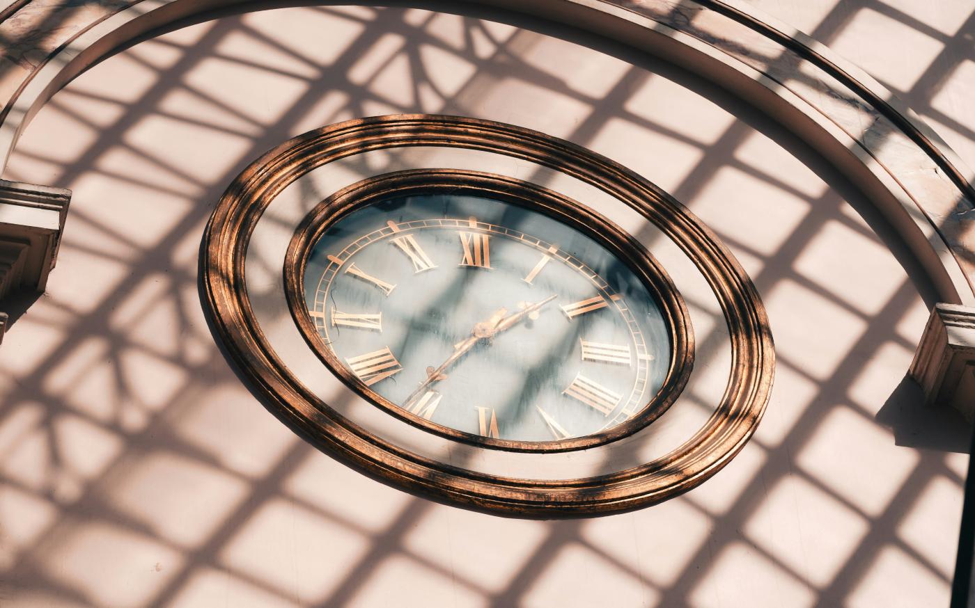 a clock that is on the side of a building by Maurice Sahl courtesy of Unsplash.