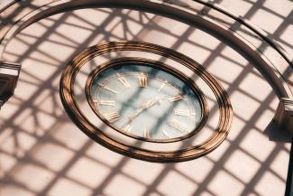 a clock that is on the side of a building by Maurice Sahl courtesy of Unsplash.