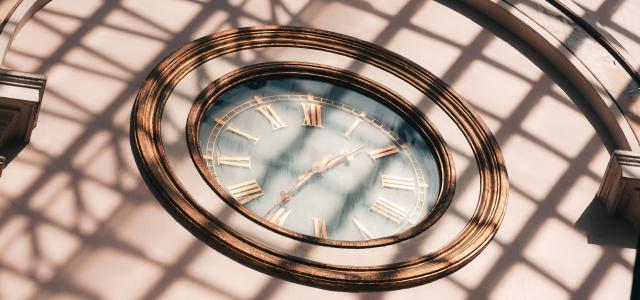 a clock that is on the side of a building by Maurice Sahl courtesy of Unsplash.